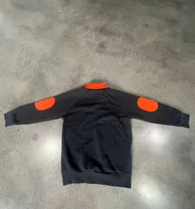 Achteraanzicht van zware grijze sweatshirt met oranje elleboogstukken en opstaande kraag.