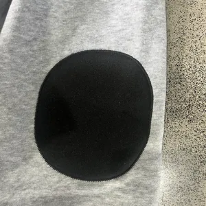 Detailopname van grijs heavyweight fleece sweatshirt met zwarte ronde elleboogpatch erop