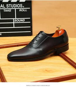 Vista lateral de zapatos Oxford de cuero negro con acabado pulido y horma de madera