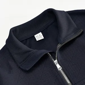 Detail of navy half-zip sweatshirt showing ribbed collar and textured jacquard fabric.