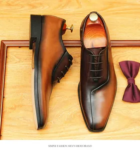 Detalle de zapatos Oxford de cuero marrón con una elegante pajarita