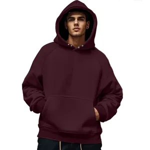 Detail shot of a men's burgundy oversized fleece hoodie with a front pocket.
