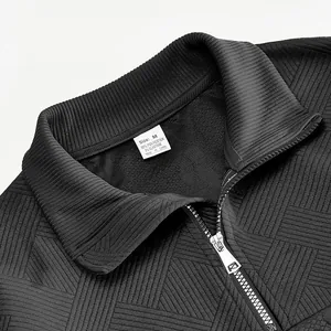 Close-up of black jacquard quarter-zip sweatshirt collar and fabric texture detail