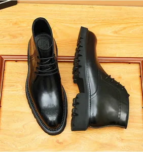 Detalle de botas de cuero negro para hombre con patrones brogue y suela de ganchos.