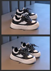 Detailansicht von flachen Kinder-Sportschuhen im schwarz-weißen Farbblock-Design für Schüler.