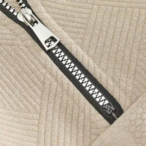 Macro detail of high-quality metal zipper on khaki jacquard heavyweight sweatshirt