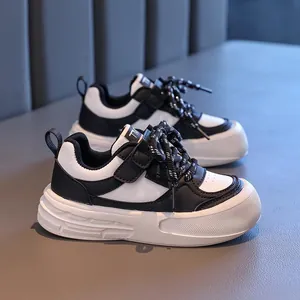 Klassische schwarz-weiße Kindersneaker mit Klettverschluss und dicker Anti-Rutsch-Sohle
