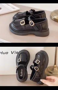 Close-up of black British style girls' Mary Jane shoes with double gold buckles
