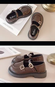 Detail showing double straps and gold buckles on brown Mary Jane shoes for girls