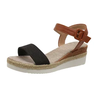 Detailed side view of women's wedge sandal featuring a black front strap and brown buckle closure