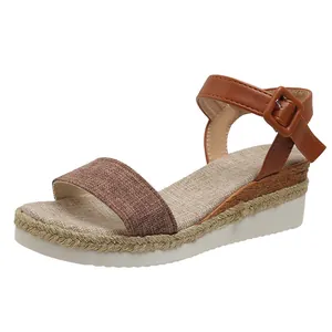 Detailed side view of a women's brown platform wedge sandal with a woven ankle strap