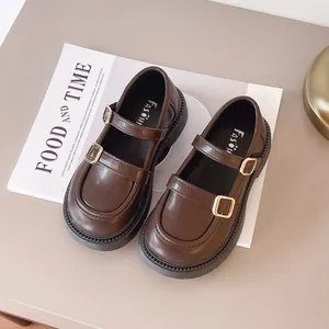 Classic dark brown British style Mary Jane shoes for girls with gold buckle details.
