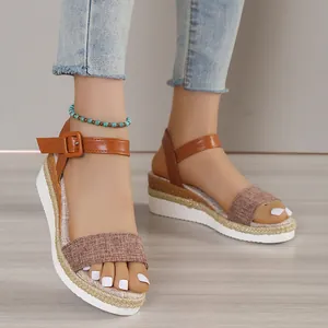 Close-up detail of women's brown wedge sandals with espadrille trim and ankle strap