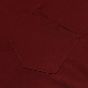 Macro close-up detail of the chest pocket and stitching on a burgundy men's cotton T-shirt