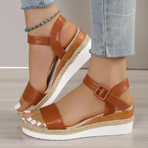 Detail view of women's brown leather wedge sandals featuring a woven espadrille platform sole.