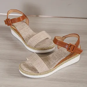 Detailed view of women's platform wedge sandals with brown ankle strap and linen texture