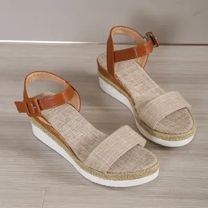 Close-up of women's platform wedge sandals with brown buckle straps