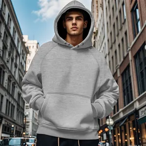 Detailed view of grey men's hoodie with hood and front pocket worn in an urban street
