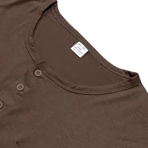 Close-up detail of a brown Henley t-shirt neckline with buttons and size tag