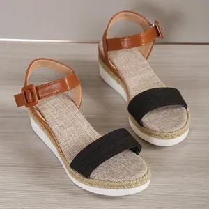 Close-up of women's platform wedge sandals with brown ankle strap and black front band