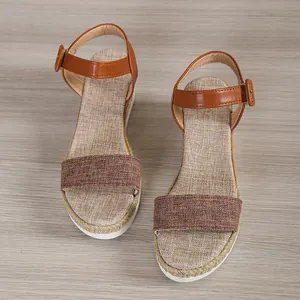Detailed view of brown linen-textured platform wedge sandals with ankle straps.