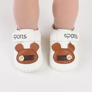 Dettaglio scarpine primi passi bianche per neonato con decoro orsetto e cinturino sports