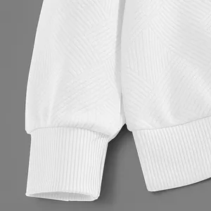 Gros plan d'un sweat blanc lourd 300G montrant la texture jacquard et les poignets