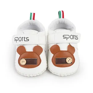 Vista dettagliata dall'alto di scarpe primi passi bianche per neonati con orsetto marrone