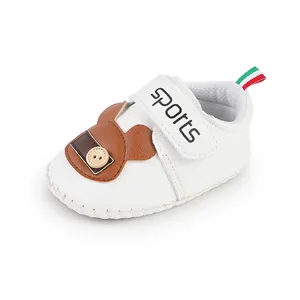 Dettaglio scarpa primi passi bianca per neonato con motivo orso e cinturino velcro