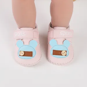 Primo piano di graziose scarpine rosa per neonati con orso blu per bimbi 0-1 anno
