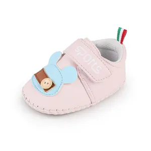 Primo piano di una scarpa da primi passi rosa per neonati con simpatica toppa a orsetto