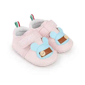 Vista laterale di scarpe da neonato rosa con toppa a forma di animale e chiusura a strappo