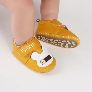 Dettaglio di scarpe da camminata gialle per neonati con coniglietto e suola antiscivolo