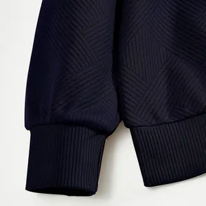 Gros plan sur les poignets côtelés et le tissu jacquard d'un sweat-shirt lourd bleu pour hommes