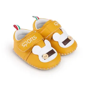 Dettaglio scarpe da camminata gialle per neonati con design a topo e velcro