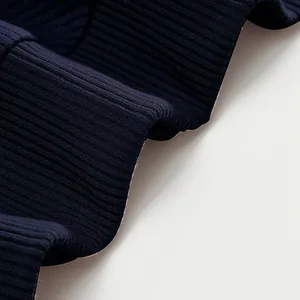 Vue macro détaillée montrant la texture épaisse du tissu côtelé bleu marine d'un sweat lourd
