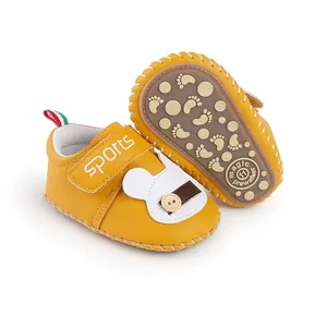 Primo piano scarpe gialle primi passi bimbo con suola antiscivolo e dettaglio coniglio