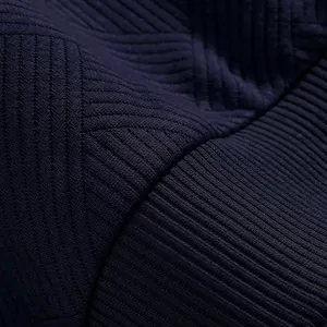 Dettaglio macro della trama a coste su un pesante tessuto jacquard blu navy per felpa