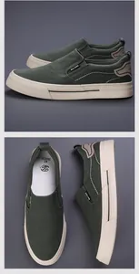 Detail view of men's casual green canvas slip-on shoes with beige rubber soles.