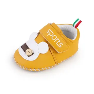 Primo piano di scarpa gialla per neonati con orsetto e cinturino velcro 'sports'