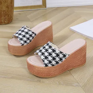 Gros plan de mules compensées pour femmes avec motif pied-de-poule et semelle tressée