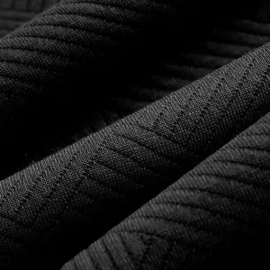 Gros plan sur la texture du tissu jacquard noir d'un sweat-shirt rétro lourd pour homme