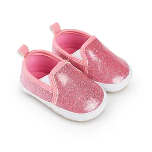Detailansicht der glitzernden rosa Babyschuhe mit weißen Sohlen und Gummizügen