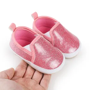 Detailaufnahme von rosafarbenen Glitzer-Babyschuhen mit weicher Textur und elastischem Band
