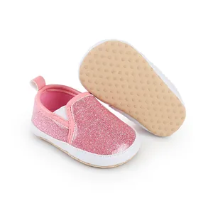 Detail von rosa glitzernden Lauflernschuhen mit rutschfesten Noppensohlen.