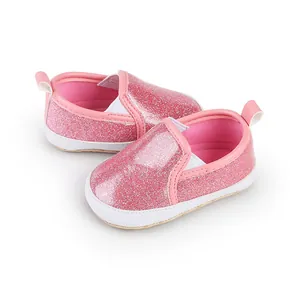 Detailansicht von glänzenden rosa Glitzer-Babyschuhen mit bequemen weißen Sohlen