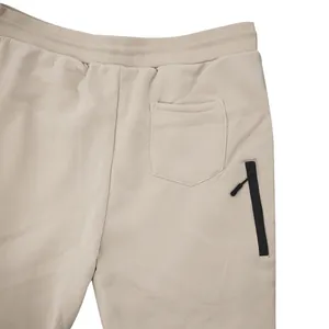 Detaillierte Nahaufnahme der khakifarbenen Fleece-Jogginghose mit Gesäßtasche und Reißverschluss.