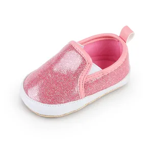 Nahaufnahme eines rosa glitzernden Babylaufschuhs mit einer weichen weißen Sohle