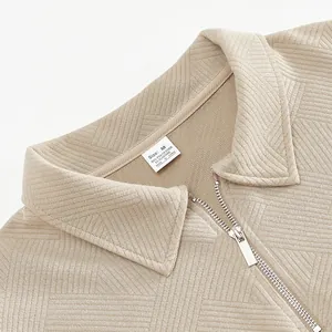 Gros plan sur la texture jacquard et le demi-zip argenté d'un sweat polo vintage