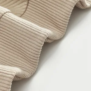 Vue macro montrant la texture détaillée du tissu en maille côtelée beige d'un sweat lourd